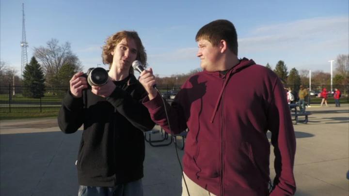 Two PM TV Production students from Clarkston High School conduct interviews outside the football field. 