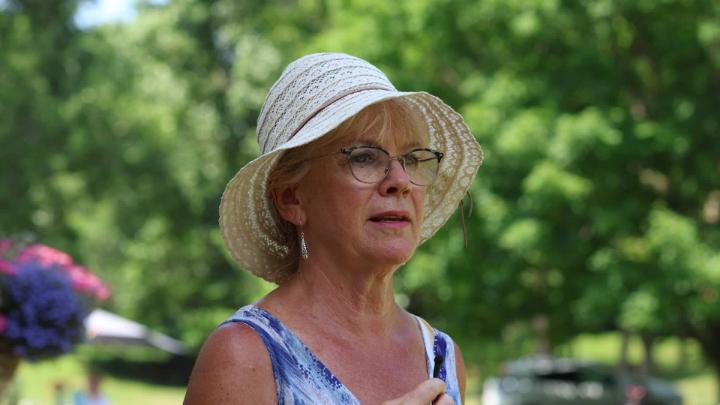 A woman holds a microphone. 